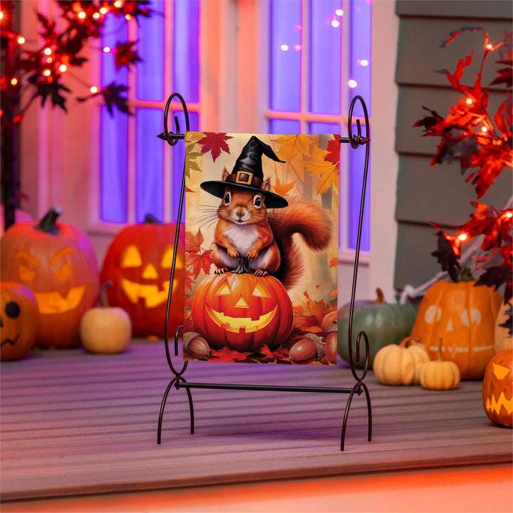 Halloween squirrel garden flag displayed beside a porch with pumpkins and fall flowers