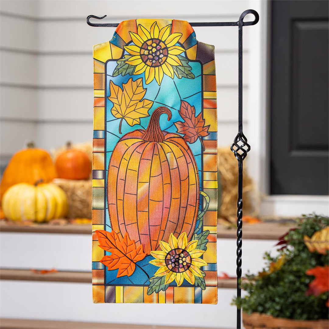 Fall Pumpkin Stained Glass 2 Sided Long Garden Flag hanging on stand with pumpkins and hay bales