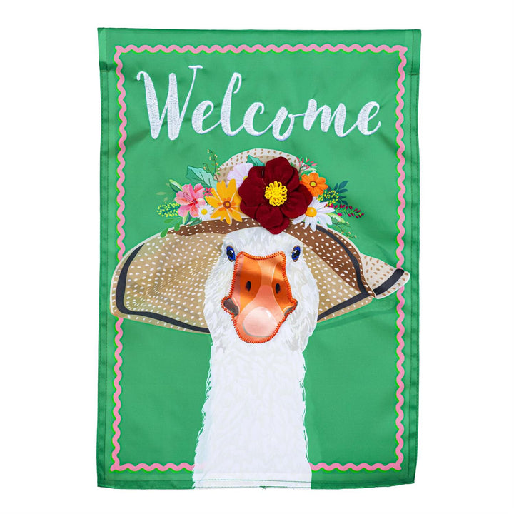 Flowery Goose 2 Sided Garden Flag - product flat lay showing white goose wearing a floral straw sun hat with Welcome embroidery on green background