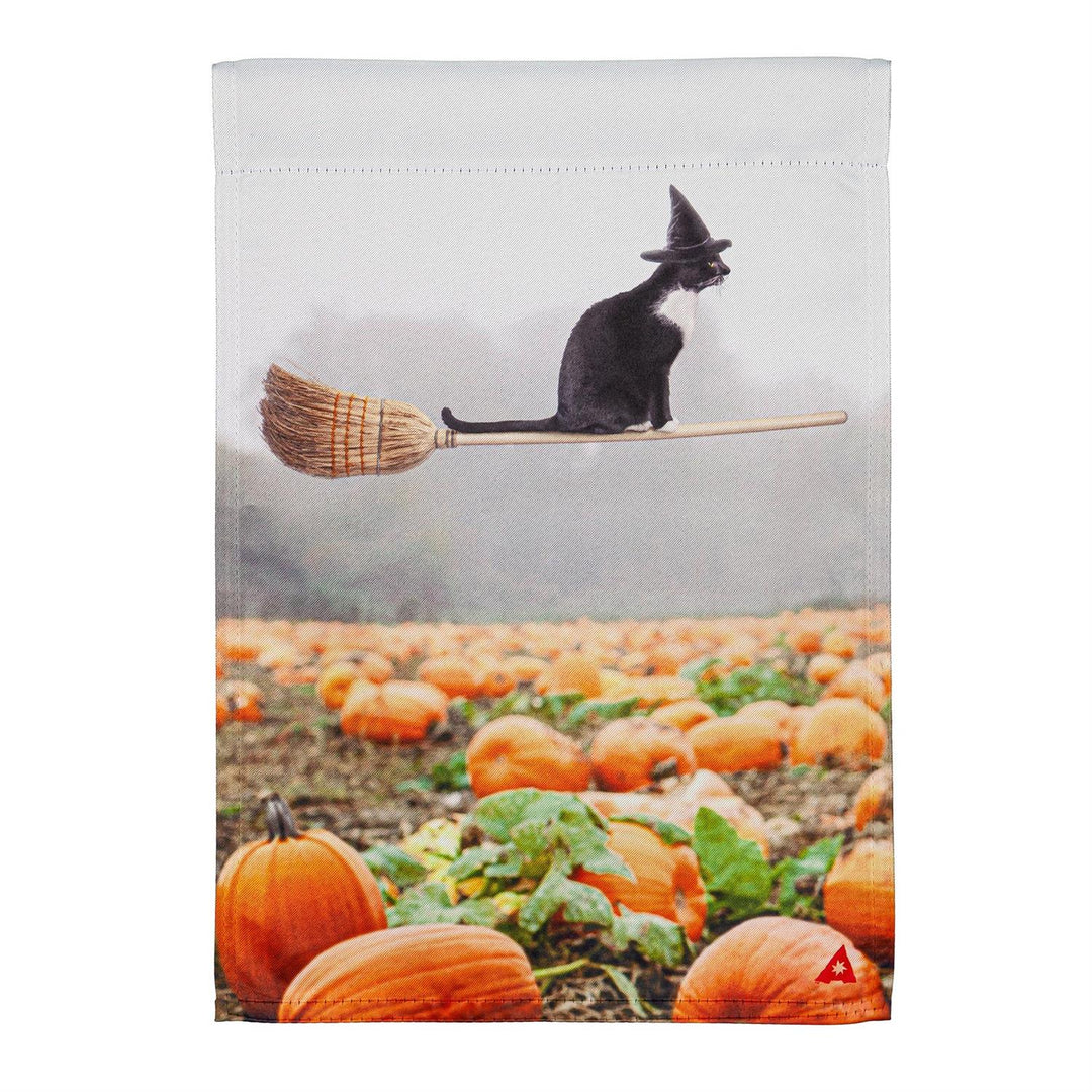 Flat view of the Flying Cat 2 sided Halloween garden flag, polyester, 12.5 x 18 inches, with a black cat in a witch hat flying on a broom above a pumpkin patch