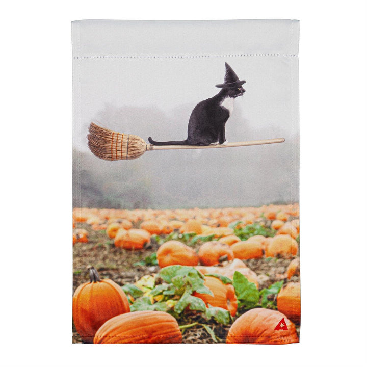 Flat view of the Flying Cat 2 sided Halloween garden flag, polyester, 12.5 x 18 inches, with a black cat in a witch hat flying on a broom above a pumpkin patch