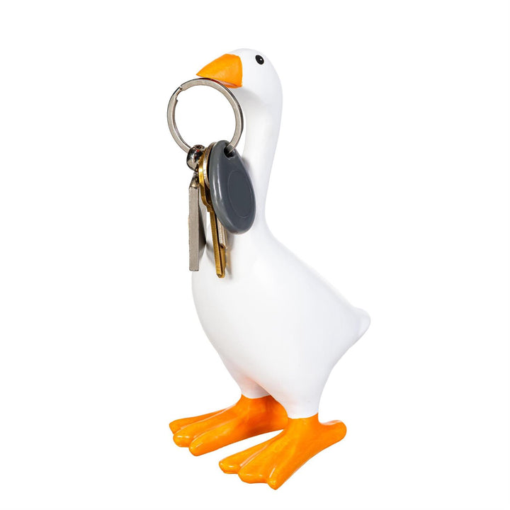 Gordy the Desktop Goose holding keys at his beak beside a laptop