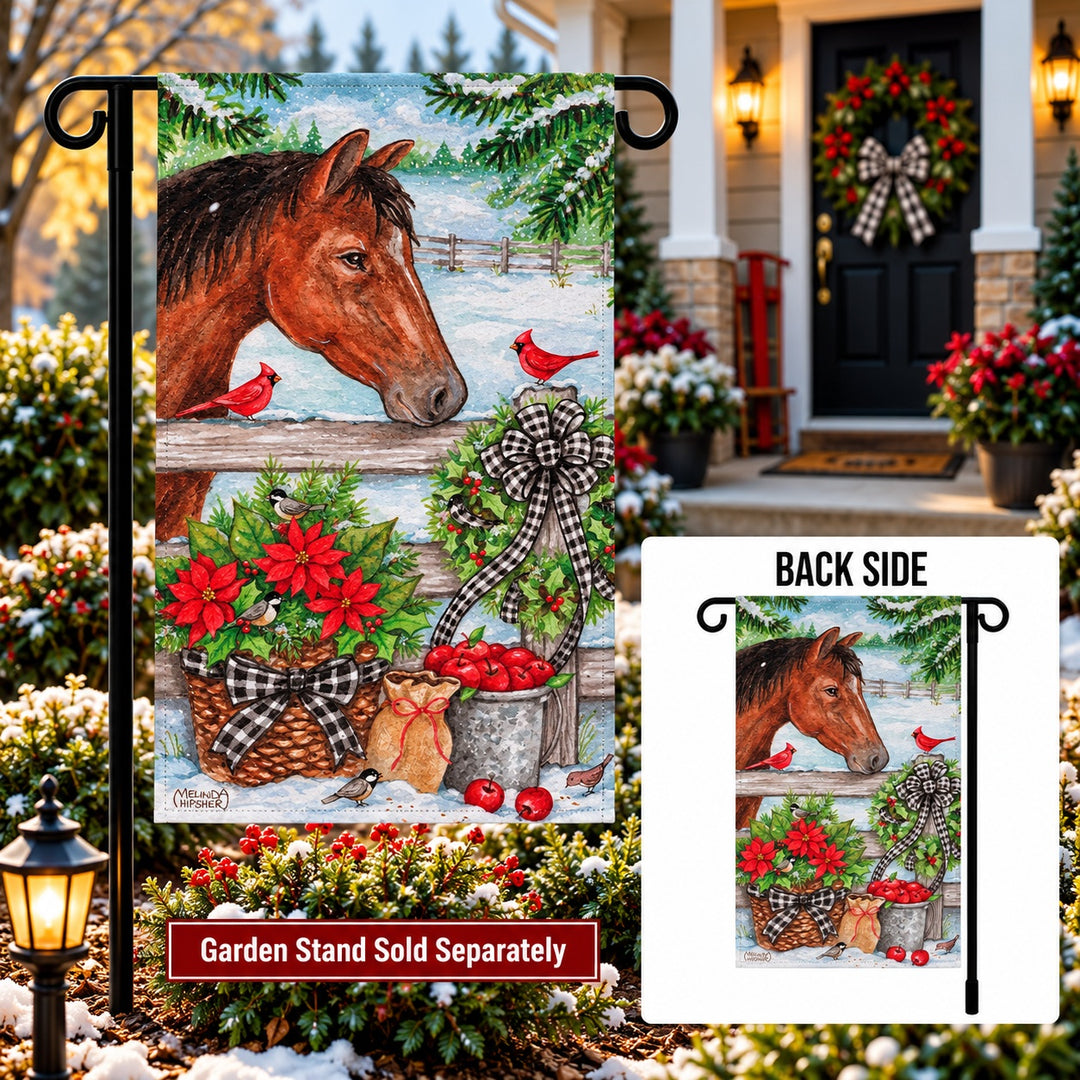 Winter horse and cardinals garden flag displayed on a decorative wall hanger beside evergreen branches
