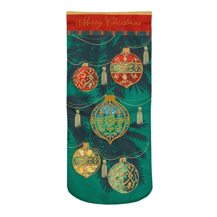 Close-up of red and green ornament with gold-colored scrollwork and stitched edging on Christmas flag fabric