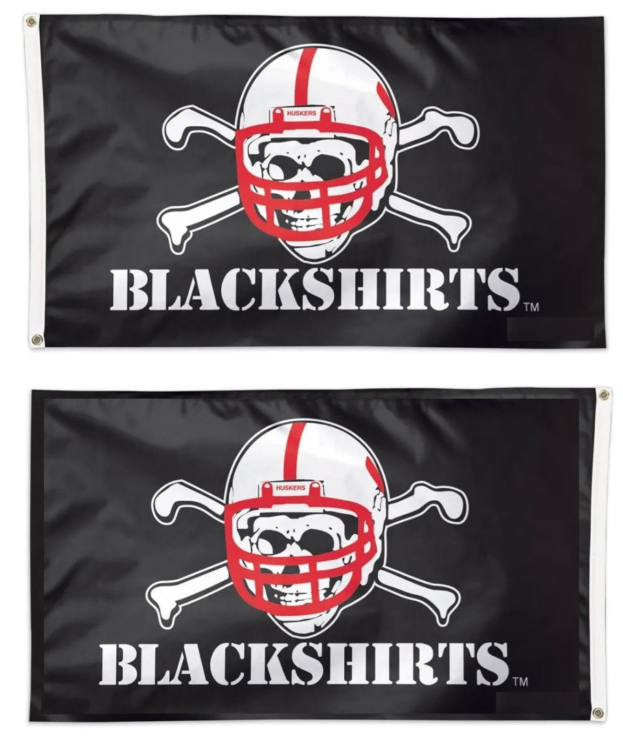Two Blackshirts flags with a helmet and crossbones design on a black background.