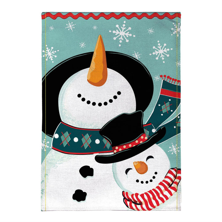 Snowman Pair winter garden flag displayed on a porch beside a sled and greenery