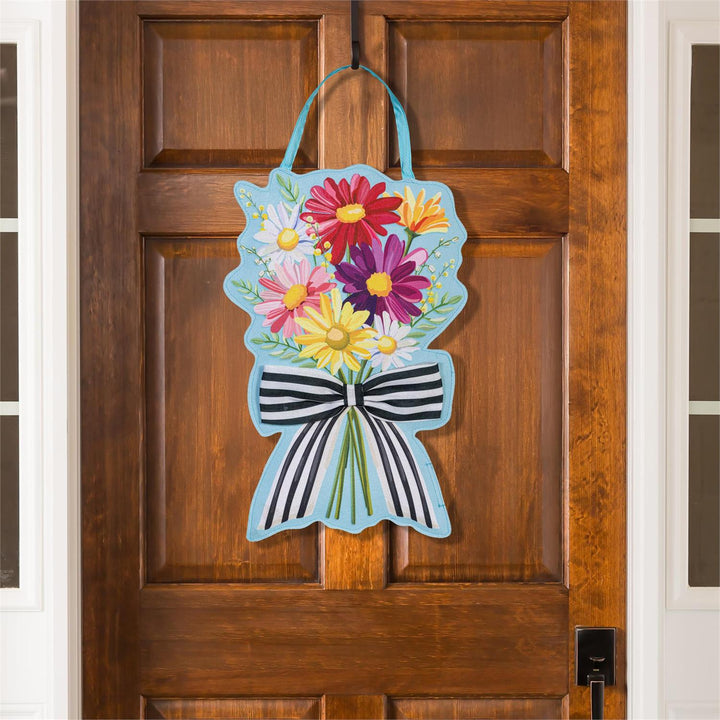Summer Daisy Bow Bouquet Door Decor - daisy side displayed hanging on a wood front door showing full bouquet silhouette with stripe bow