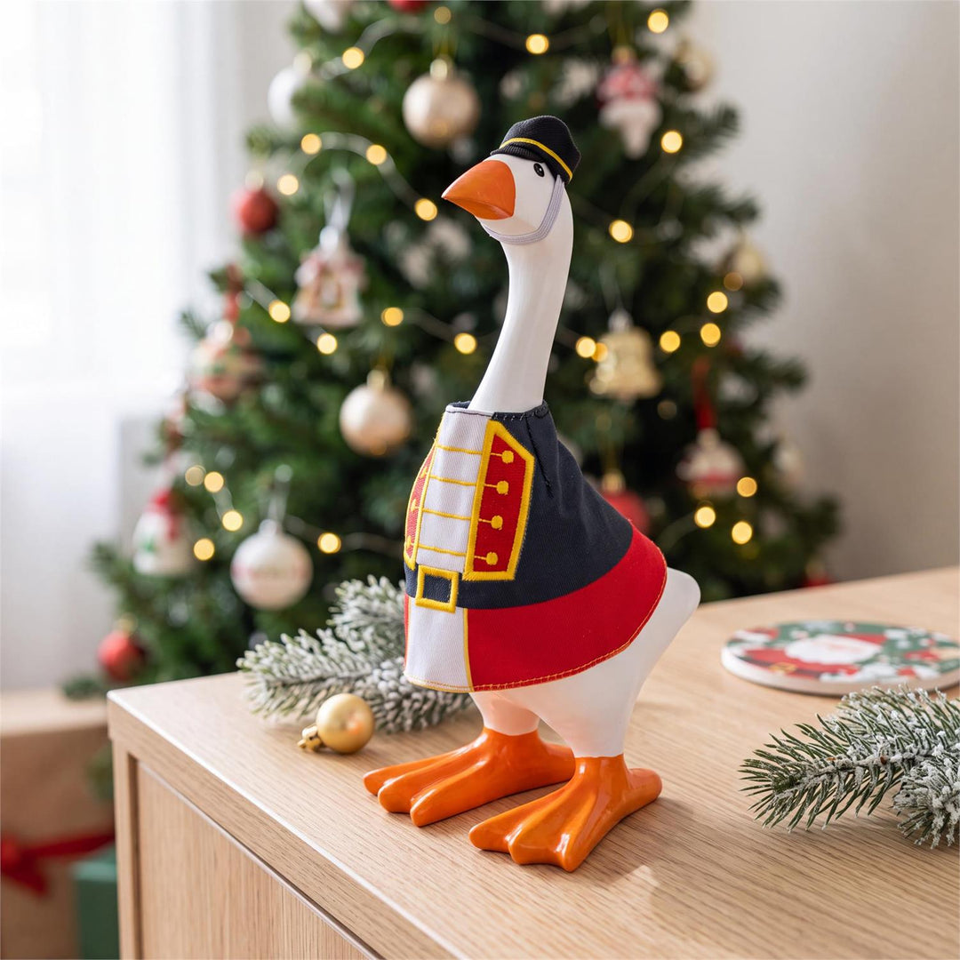 Gordy in a nutcracker costume displayed beside Christmas greenery and ornaments