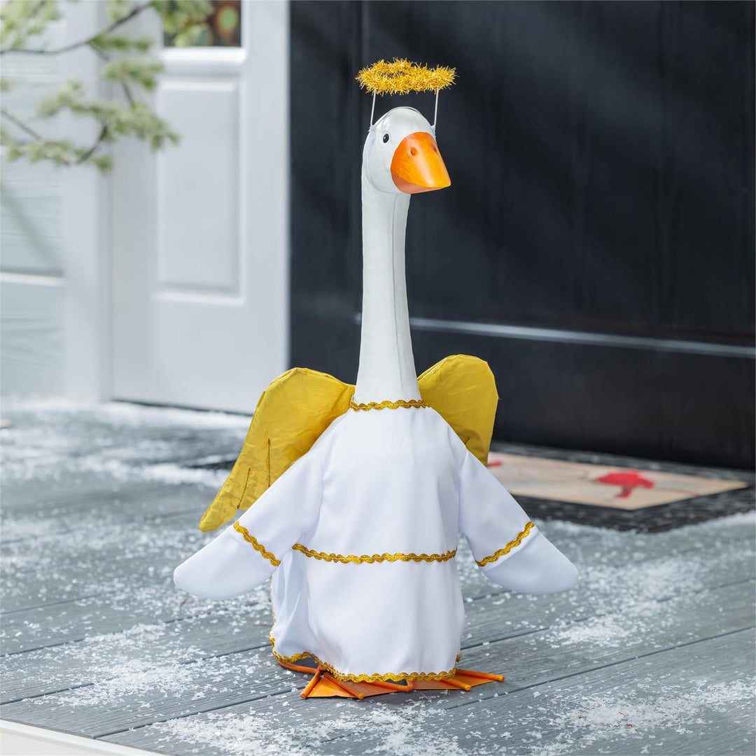 Porch goose wearing white angel robe with gold trim, gold wings, and tinsel halo beside an entry door
